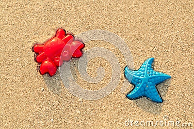 Plastic colored shapes for children play with sand on the beach. Baby plastic molds lying in the sand on the seabeach Stock Photo
