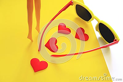 Plastic doll girl`s legs , hearts and sunglasses, travel and beauty concept. Minimal funny and quirky design still life Stock Photo