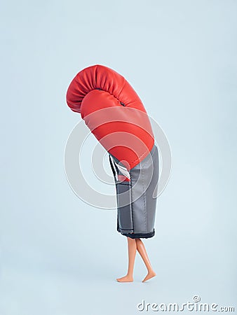 Plastic doll legs walking in heavy red boxing glove Stock Photo