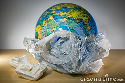Plastic with earth inside and some trash. Earth is being destroyed because of too much garbage like plastic Stock Photo