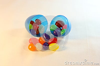 Plastic egg with jelly beans spilling out Stock Photo