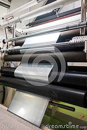 Plastic film rolls inside plastic and aluminium food packaging making machine inside factory Stock Photo
