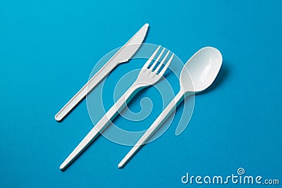 Plastic Fork, Spoon and Knive on Blue Background Stock Photo