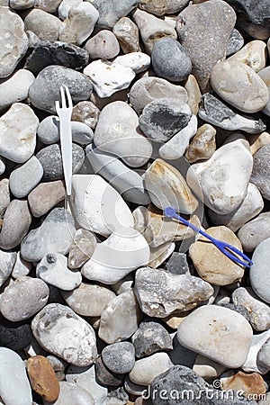 Plastic forks on ocean beach for human disrespect to water Stock Photo