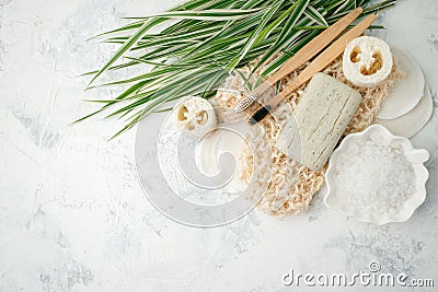 Plastic free background. Personal care products made from natural materials: bamboo tooth brushes, cotton pads, soap, green leaf. Stock Photo