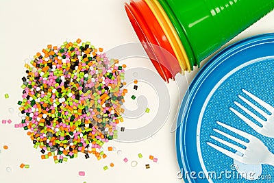 Plastic granules and disposable tableware made of polyethylene, polypropylene against the background of a polymeric material. BPA Stock Photo