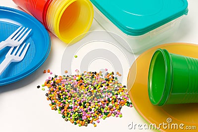 Plastic granules and disposable tableware made of polyethylene, polypropylene polymeric material on a white background. BPA FREE Stock Photo