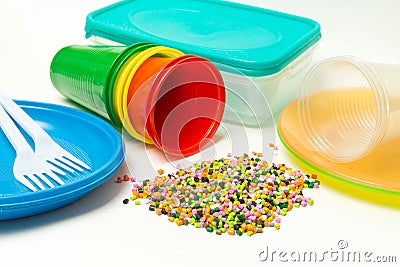 Plastic granules and disposable tableware made of polyethylene, polypropylene polymeric material on a white background. BPA FREE Stock Photo