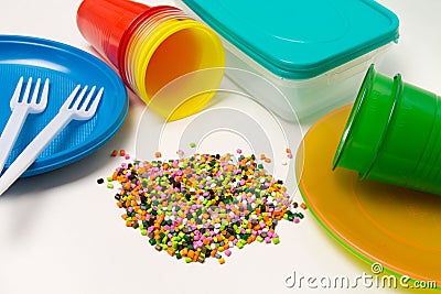 Plastic granules and disposable tableware made of polyethylene, polypropylene polymeric material on a white background. BPA FREE Stock Photo