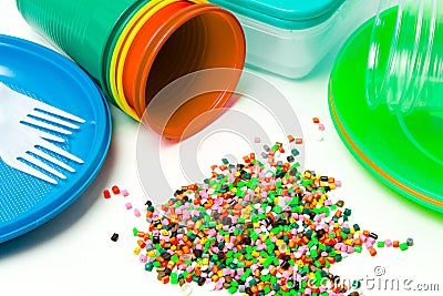 Plastic granules and disposable tableware made of polyethylene, polypropylene polymeric material on a white background. BPA FREE Stock Photo