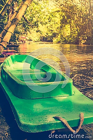 Plastic green boat and calm river with bamboo trees on nature ba Stock Photo