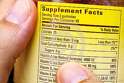 Plastic jar with supplement facts of multivitamins in woman hand Stock Photo