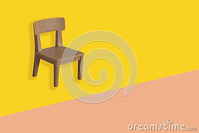 Plastic model of a brown chair on a yellow background, workplace, concept of the daily routine of a freelancer, programmer, Stock Photo