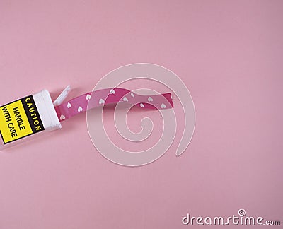 Plastic package with caution handle with care writing. Washy tapes with hearts coming out Stock Photo