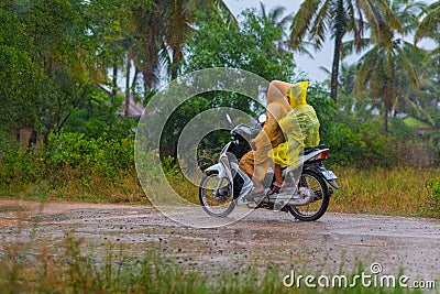 Plastic raincoats while riding a scooter in Cambodia Editorial Stock Photo