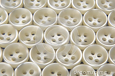 Plastic shiny buttons for clothes on a fabric background. Fashion and clothing. Factory industry Stock Photo