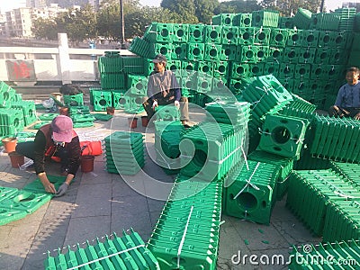 Plastic splints are used to hold flowers and workers are cleaning and installing them. Editorial Stock Photo