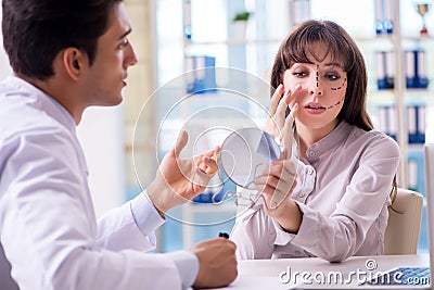 The plastic surgeon preparing for operation on woman face Stock Photo