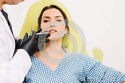 Plastic surgeon using syringe for lip augmentation. Medical procedure close up with beautiful female Stock Photo