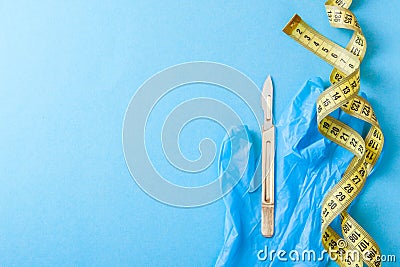 Plastic surgery of the body and face. Surgery for weight loss, liposuction, skin tightening, remove fat. Scalpel and tape Stock Photo