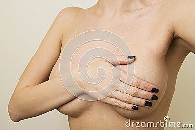 Plastic surgery concept. Woman contols her breast Stock Photo