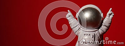 Plastic toy astronaut on colorful red background Copy space. Concept of out of earth travel, private spaceman commercial Stock Photo