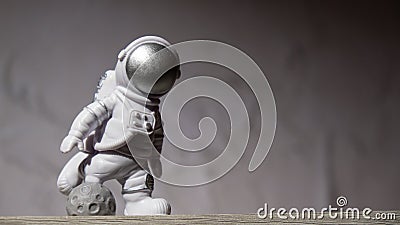 Plastic toy figure astronaut on moon concrete background Copy space. Concept of out of earth travel, private spaceman Stock Photo