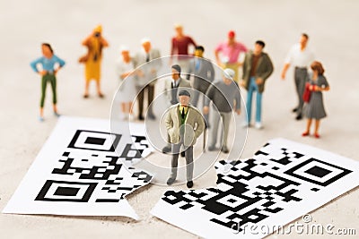 Plastic toy men and a sheet torn in half with a barcode, the concept of a rally of people against the introduction of the QR code Stock Photo