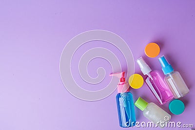 Plastic travel bottles on lavender background. Travel containers with colorful tops. Stock Photo