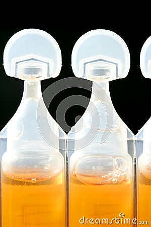 Plastic white ampoule of orange medicine Stock Photo