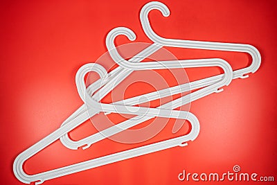 Plastic white coat hangers clothes hanger on red background Stock Photo