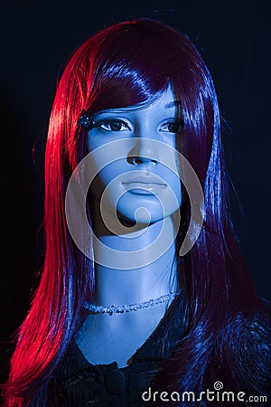 Mannequin with bright long red hair posing on a black background Stock Photo