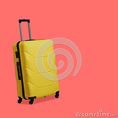 Plastic Yellow suitcase isolated on pink background. Suitcase with wheels and retractable telescopic handle. Travel Stock Photo