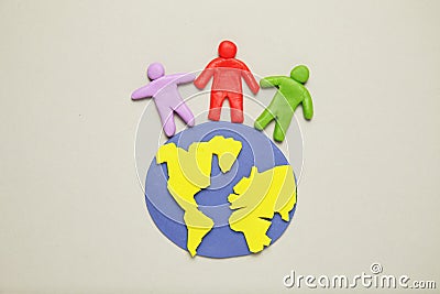 Plasticine figurines of people of different races are on planet earth. A variety of interactions, communication and globalization Stock Photo