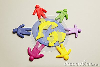 Plasticine figurines of people of different races are on planet earth. A variety of interactions, communication and globalization Stock Photo