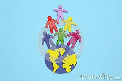 Plasticine multicolored cartoon people on globe. The use and depletion of the planet earth, overpopulation and population growth Stock Photo