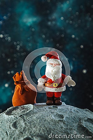 Plasticine Santa Claus with a bag of gifts on the moon Stock Photo
