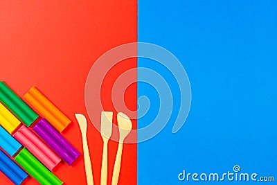 Plasticine for sculpting in different colors and a tool for working with it. Top view. Copy your text Stock Photo