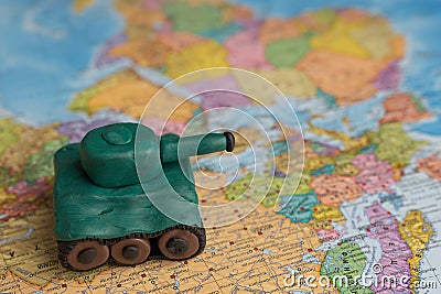 A plasticine tank on the background of a world map, as a symbol of peace and goodness. There is no war appeal. Stop war Stock Photo