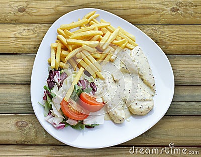 Plate with Aromatic Chicken french fries and mixed salad Stock Photo