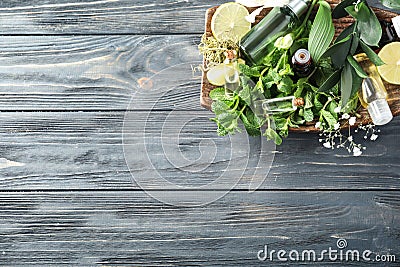 Plate with citrus essential oil, lime and herbs on wooden background Stock Photo