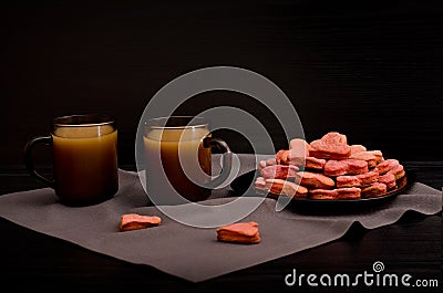 A plate of cookies with red heart-shaped, mugs of coffee with milk, Valentine's Day Stock Photo