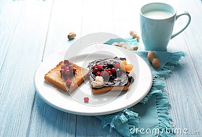 Plate with creative sweet toasts and cup of milk on table Stock Photo