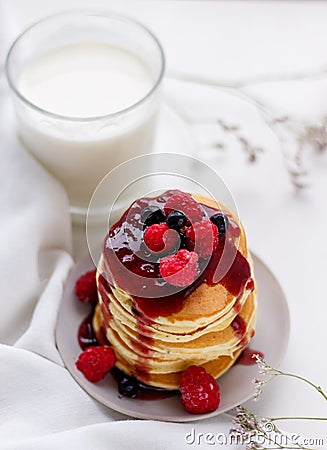 Plate with delicious pancakes with raspberries and berry sauce on white background Stock Photo