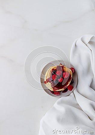 Plate with delicious pancakes with raspberries and berry sauce on white background. Top view copy space Stock Photo