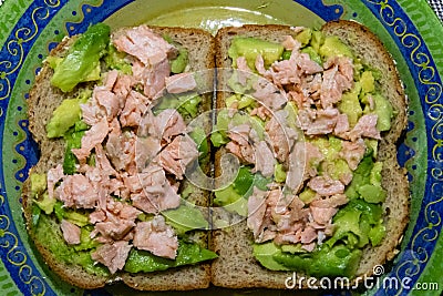 Plate with a double sandwich containing raw avocado and fried salmon only Stock Photo