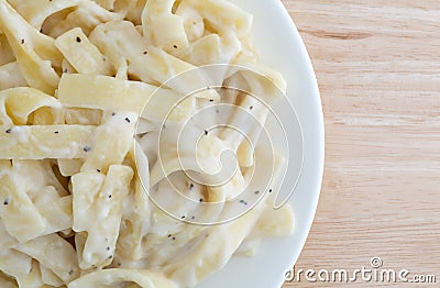 Plate of fettuccine alfredo on wood table top close view Stock Photo