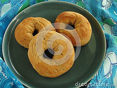 Plate of fresh baked Italian anise seed donuts on blue and green tablecloth with retro design Stock Photo