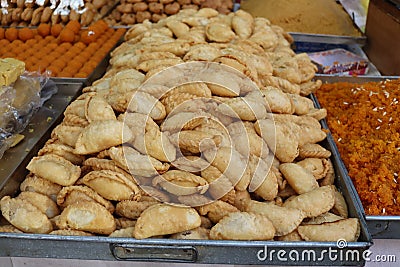 A plate full of crispy Indian snacks- Gujiya prepared during the festival of Colors. Holi is celebrated by eating delicious food Stock Photo