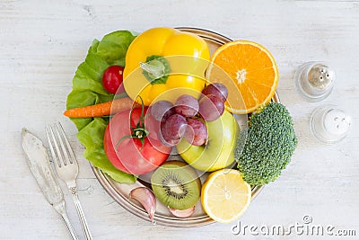 Plate full of fruits and vegetables, cutlery, spices. Healthy meal Stock Photo
